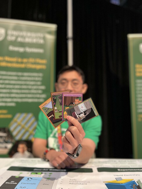 Energy Explorer Mark Cui holding Energy Adventures trading cards