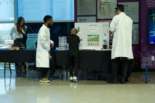  Bamlak Setegne (left) and Amirhossein Taghipour (right) share their demonstration with a child.